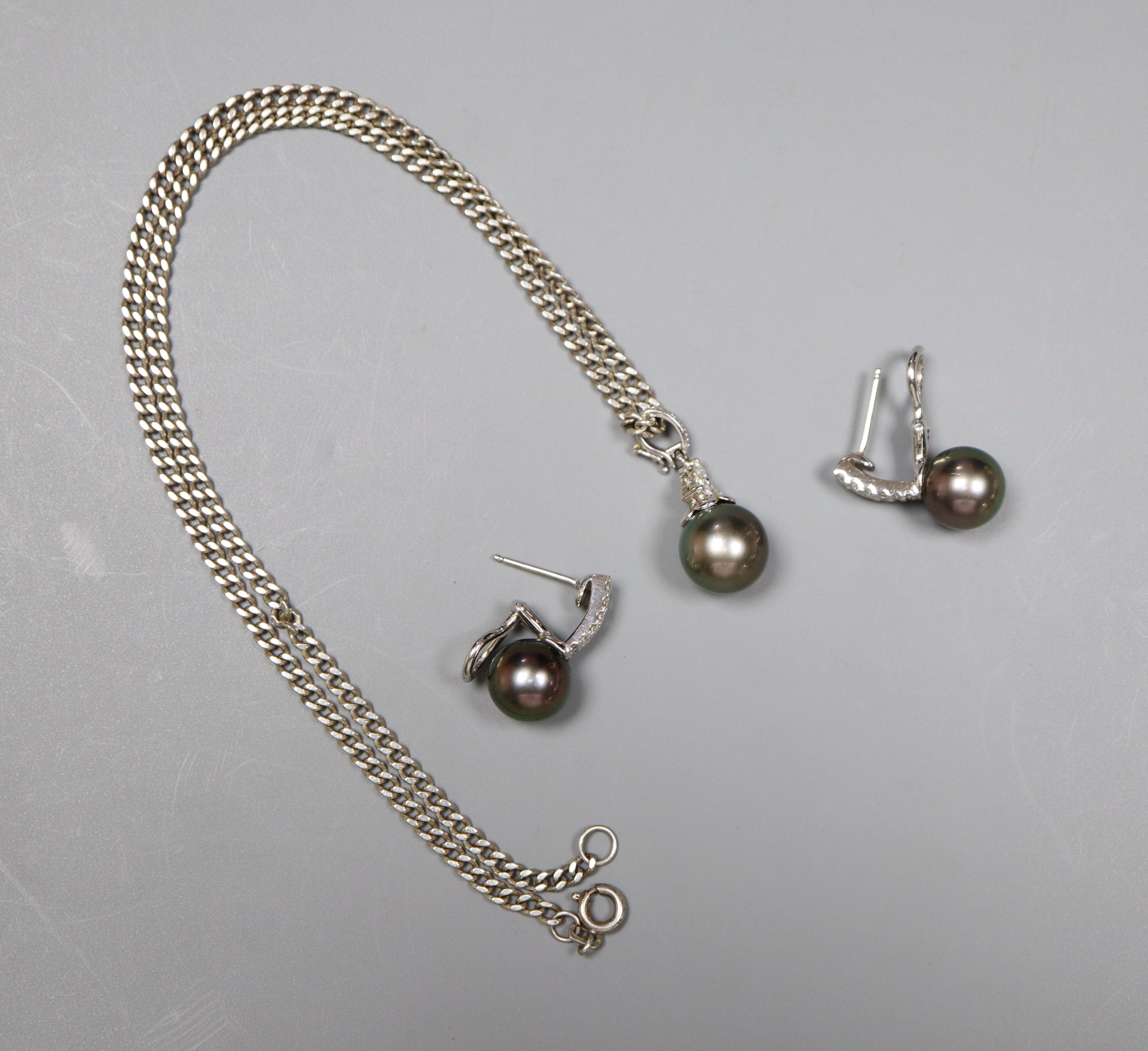 A modern 18k white metal , cultured Tahitian? pearl and diamond set pendant and pair of matching earrings.